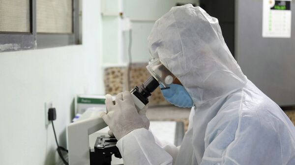 Сотрудник лаборатории смотрит в микроскоп. Архивное фото - Sputnik Кыргызстан