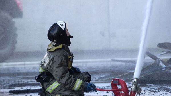 Сотрудник пожарной службы МЧС во время тушения возгорания. Архивное фото - Sputnik Кыргызстан