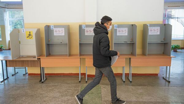 Парень у кабинок для голосования на избирательном участке. Архивное фото - Sputnik Кыргызстан