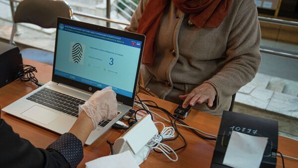 Женщина проходит биометрическую идентификацию на выборах седьмого созыва ЖК - Sputnik Кыргызстан