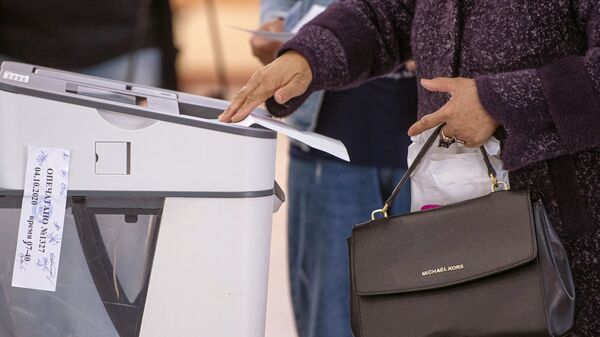 Женщина опускает бюллетень в урну для голосования. Архивное фото - Sputnik Кыргызстан