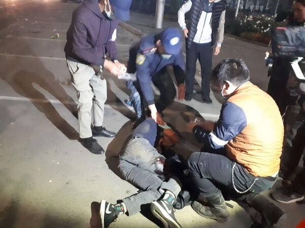 Митингчилердин бири бутунан жаракат алып канжалап жерде жатат. Сүрөт, видео - Sputnik Кыргызстан