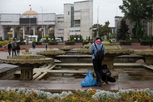 Две девушки собирают мусор у фонтана на площади Ала-Тоо - Sputnik Кыргызстан