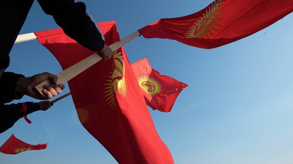 Митингующие на площади Ала-Тоо в Бишкеке держат флаг Кыргызстана - Sputnik Кыргызстан