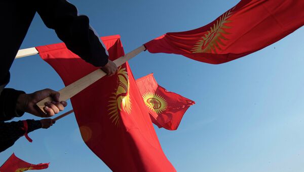 Митингующие на площади Ала-Тоо в Бишкеке держат флаг Кыргызстана - Sputnik Кыргызстан
