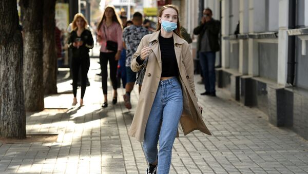 Девушка в медицинской маске на одной из улиц города - Sputnik Кыргызстан