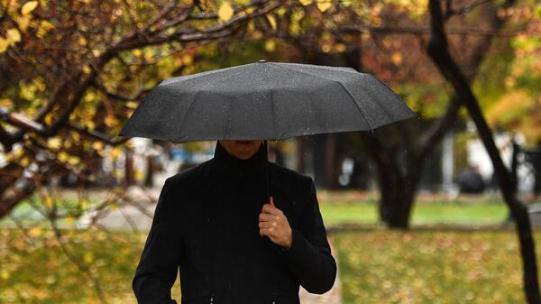 Мужчина с зонтом во время дождя. Архивное фото - Sputnik Кыргызстан
