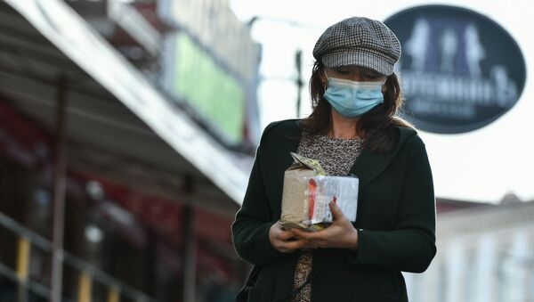 Девушка в защитной маске идет по улице. Архивное фото - Sputnik Кыргызстан