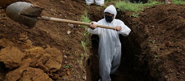 Мужчина в СИЗ копает могилу для умершего от COVID-19. Архивное фото - Sputnik Кыргызстан