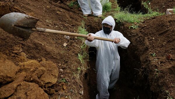 Мужчина в СИЗ копает могилу для умершего от COVID-19. Архивное фото - Sputnik Кыргызстан