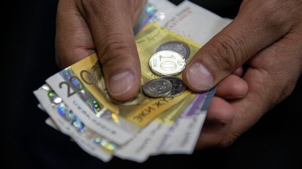 Мужчина держит деньги. Иллюстративное фото - Sputnik Кыргызстан