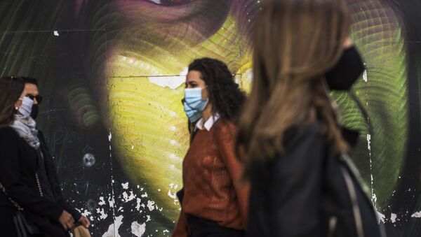 Прохожие в защитных масках на улице Гран-Виа в Мадриде. Архивное фото - Sputnik Кыргызстан