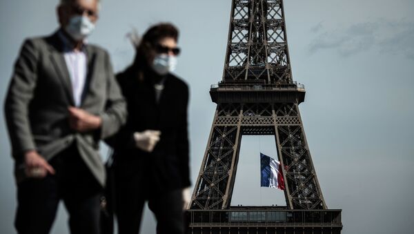 Мужчина и женщина в масках на фоне Эйфелевой башне в Париже. Архивное фото - Sputnik Кыргызстан