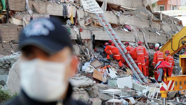 Спасатели разбирают завалы разрушенного из-за сильного землетрясение дома в городе Измир (Турция) - Sputnik Кыргызстан