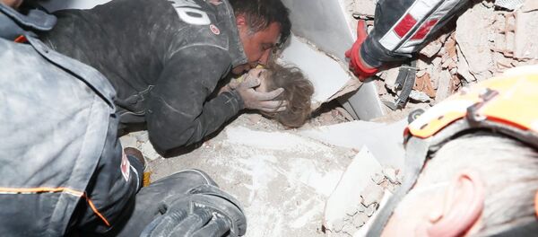 Спасатели вытаскивают ребенка из-под завала в результате землетрясения в Измире, Турция - Sputnik Кыргызстан