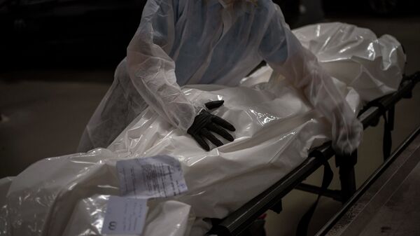 Медик с телом человека, умершего от COVID-19 в морге. Архивное фото - Sputnik Кыргызстан