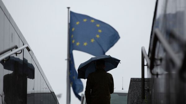 Мужчина с зонтиком идет в сторону флага Евросоюза. Архивное фото - Sputnik Кыргызстан