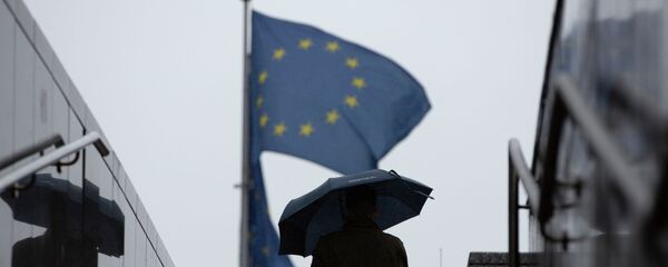 Киши Евробиримдиктин желектеринин жанында кол чатыр менен бара жтат. Архив - Sputnik Кыргызстан