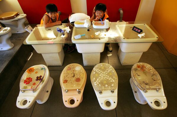 Дети едят мороженое из миниатюрных туалетов в тематическом ресторане в Гаосюне, Тайвань - Sputnik Кыргызстан