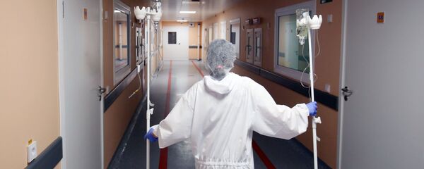 Медицинский работник несет капельницы. Архивное фото - Sputnik Кыргызстан