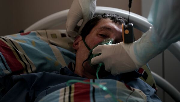 Пациенту надевают кислородную маску в стационаре для больных COVID-19. Архивное фото - Sputnik Кыргызстан