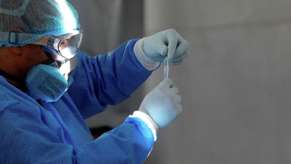 Медицинский работник в СИЗ смотрит на образец мазка, взятый у мужчины на экспресс-тест на COVID-19 - Sputnik Кыргызстан