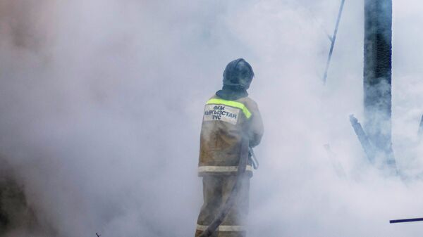 Сотрудник МЧС во время тушения пожара. Архивное фото - Sputnik Кыргызстан