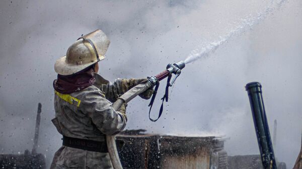 Сотрудник МЧС КР во время тушения пожара в Бишкеке. Архивное фото - Sputnik Кыргызстан
