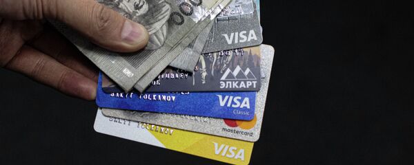 Банковские карты и тысяча сомовые купюры. Иллюстративное фото - Sputnik Кыргызстан