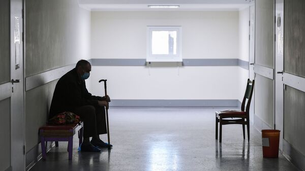 Пожилой пациент в медицинской маске ожидает приема врача в городской поликлинике. Архивное фото - Sputnik Кыргызстан