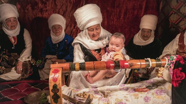 Бабушки укладывают ребенка в колыбель. Архивное фото - Sputnik Кыргызстан