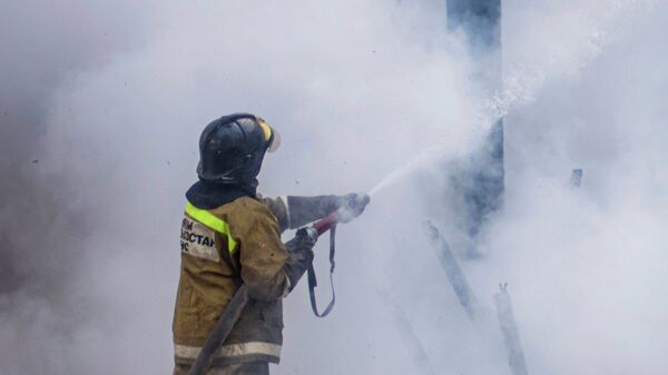 Сотрудник МЧС КР во время тушения пожара. Архивное фото - Sputnik Кыргызстан