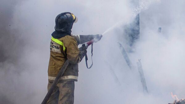 Сотрудник МЧС во время тушения пожара. Архивное фото - Sputnik Кыргызстан