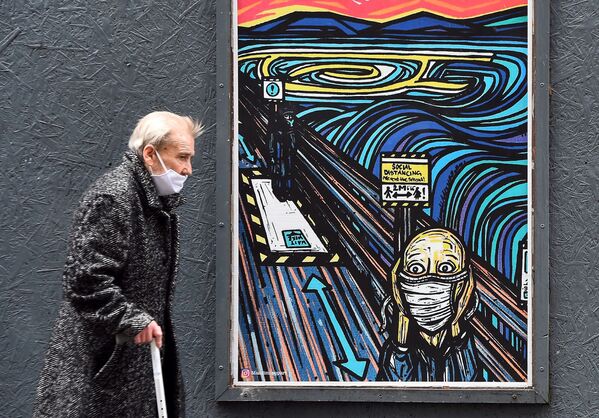 Пешеход в маске проходит мимо граффити в Глазго, Великобритания - Sputnik Кыргызстан