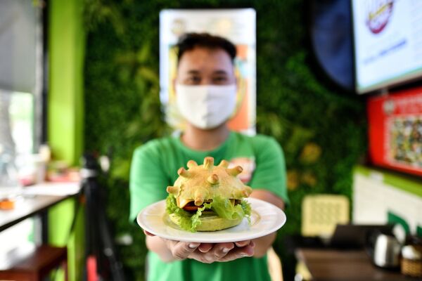Владелец ресторана Pizza Home в Ханое (Вьетнам) позирует с гамбургером на тему коронавируса  - Sputnik Кыргызстан