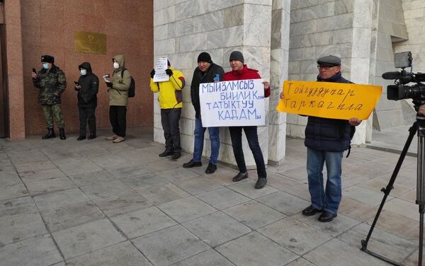 Активисты устроили для депутатов так называемую дорожку позора — они встали вдоль входа с восточной стороны здания, чтобы встречать парламентариев, приходящих на работу. - Sputnik Кыргызстан
