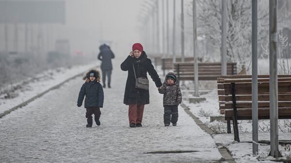 Женщина с детьми во время снегопада в Бишкеке. Архивное фото - Sputnik Кыргызстан