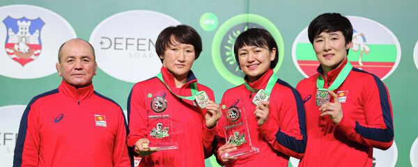 Заслуженный тренер сборной команды Кыргызстана по женской борьбе Нурбек Изабеков и борцы Айсулуу Тыныбекова, Мээрим Жуманазарова и Айпери Медет кызы. Архивное фото - Sputnik Кыргызстан