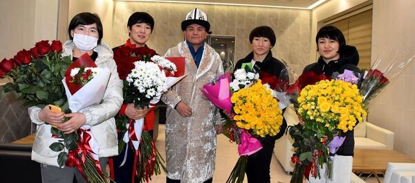 Борцы Айсулуу Тыныбековой, Мээрим Жуманазаровой, Айпери Медет кызы, а также их тренер Нурбек Изабеков в аэропорту Манас - Sputnik Кыргызстан