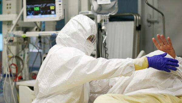 Медицинский работник осматривает пациента в отделении COVID-19. Архивное фото - Sputnik Кыргызстан