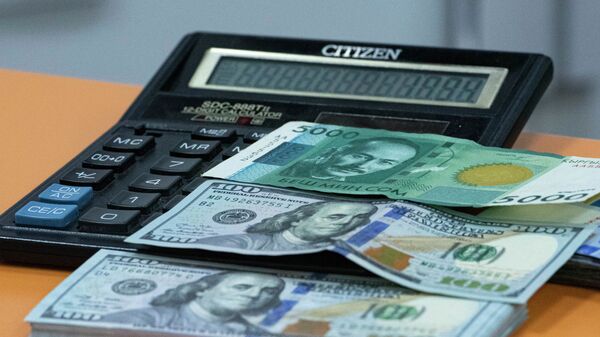 Стодолларовая и пяти тысячная сомовая купюра на калькуляторе. Иллюстративное фото - Sputnik Кыргызстан