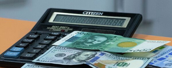  Сто долларовая и пяти тысячная сомовая купюра на калькуляторе. Иллюстративное фото - Sputnik Кыргызстан