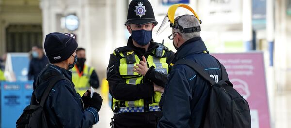 Сотрудник полиции беседует с людьми в главном вестибюле на вокзале Ватерлоо в Лондоне Сотрудник полиции беседует с людьми в главном вестибюле на вокзале Ватерлоо в Лондоне - Sputnik Кыргызстан
