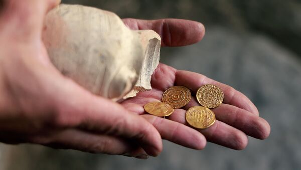 Археолог держит кувшин с золотыми монетами. Архивное фото - Sputnik Кыргызстан