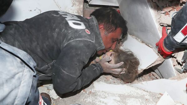 Турецкие спасатели вытаскивают ребенка из под обломков после землетрясения в Измире - Sputnik Кыргызстан
