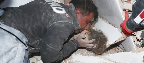 Турецкие спасатели вытаскивают ребенка из под обломков после землетрясения в Измире - Sputnik Кыргызстан