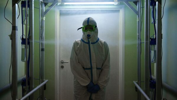 Медик в защитном противоэпидемическом костюме проходит санитарную обработку - Sputnik Кыргызстан