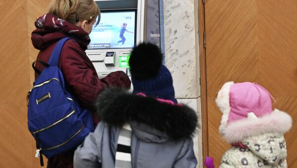 Женщина у банкомата снимает деньги. Архивное фото - Sputnik Кыргызстан