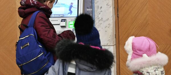 Женщина у банкомата снимает деньги. Архивное фото - Sputnik Кыргызстан