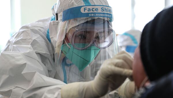 Медицинский работник берет мазок у человека для проверки на COVID-19 - Sputnik Кыргызстан